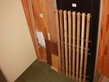 a room with a door and a bunch of baseball bats on the wall