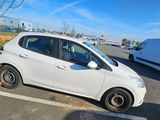 a small white car parked in a parking lot next to a bike
