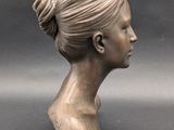 sculpture of a woman ' s head with a bun in her hair