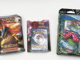 three packs of pokemon cards on a white surface