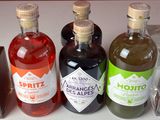 Des bouteilles d'alcool sont alignées sur un comptoir devant un mur rouge