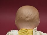 a doll that is wearing a yellow shirt and a white jacket