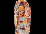 a vase with a painting on it on a stand