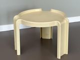 table en plastique jaune à deux pieds dans une pièce aux murs gris