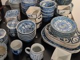 many blue and white dishes and cups on the table