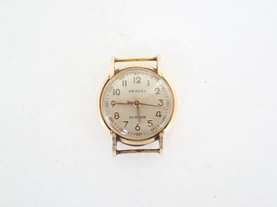 une montre-bracelet en or avec un cadran blanc sur une surface blanche
