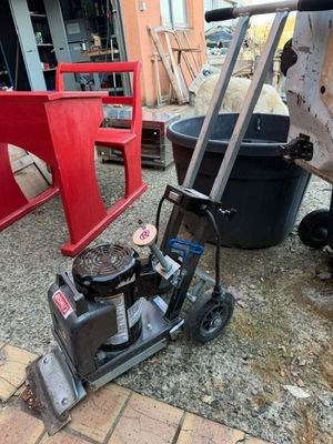 a lawn mower that is sitting on the side of the road