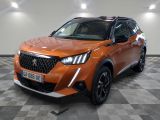 Le SUV orange est garé sur un sol carrelé à damier.