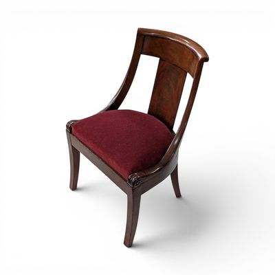 une image représentant une chaise en bois sur laquelle est posé un coussin rouge