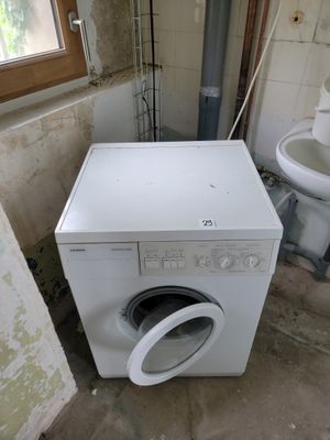 une machine à laver et des toilettes dans une salle de bains