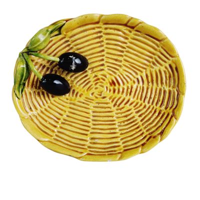 a yellow plate with two black olives on it