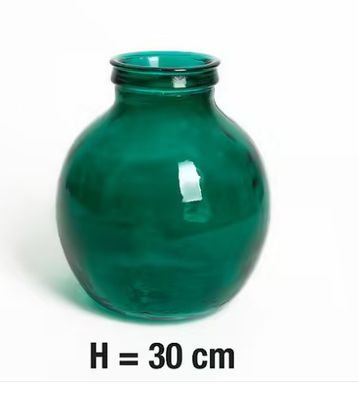 un vase vert posé sur une surface blanche
