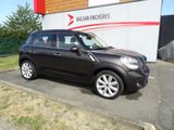 une photo d'une Mini Cooper noire garée devant un immeuble