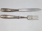 two forks and a knife on a white table