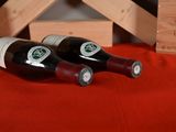 two bottles of wine sitting on a table next to a wine rack