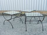 deux tables au plateau en verre sont posées sur du gravier près d'une clôture métallique
