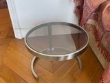 a small table with a glass top on a wooden floor