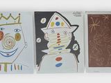 several paintings of different shapes and sizes are hanging on a wall