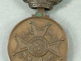 an old medal with a crown on top of it sitting on a table