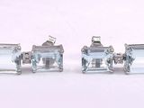 three pairs of silver earrings with aquamarinee stones on them