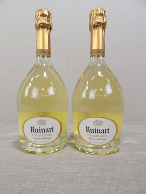 deux bouteilles de vin posées sur une table l'une à côté de l'autre