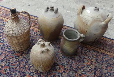 quatre vases posés sur un tapis, à même le sol