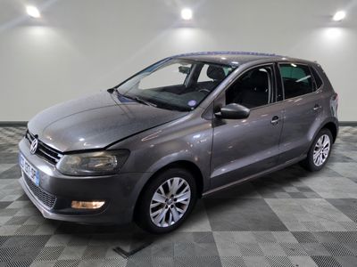 La Volkswagen Polo grise est garée sur un sol en carrelage à damier.