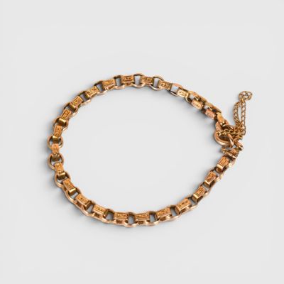 a gold chain bracelet with square links on a white background