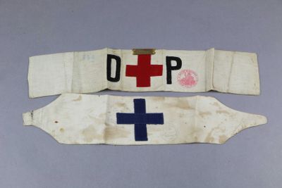 two white and blue medical sashes with a red cross on them