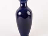 a blue vase with a gold rim sitting on a white surface