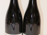 deux bouteilles de vin posées sur une table l'une à côté de l'autre