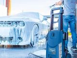 un homme en train de laver une voiture avec un nettoyeur haute pression