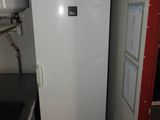 a white refrigerator in the corner of a small kitchen