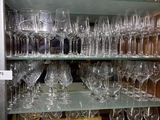 many wine glasses on the shelves in the glass case