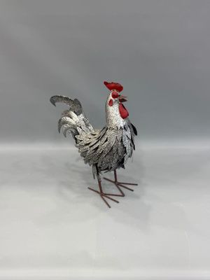 un coq en métal posé sur une surface blanche