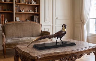une statue représentant un faisan posée sur une table basse dans un salon