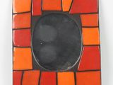 un cadre photo orange et noir posé sur une table blanche