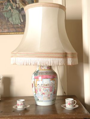 a lamp that is sitting on a table with a cup and saucer