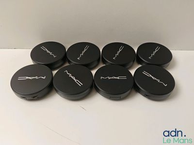Les produits Mac Cosmetics sont disposés sur une surface blanche