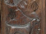 carvings of a dog and a tree in a wood frame