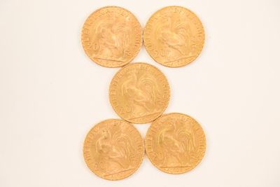 four gold coins are arranged in a row on a white surface
