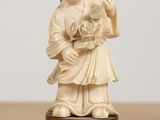 a small figurine of a boy holding a cat