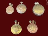 quatre types différents de pendentifs en or et en argent sur fond rouge