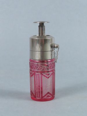 une petite bouteille en verre rose à laquelle est attachée une chaîne