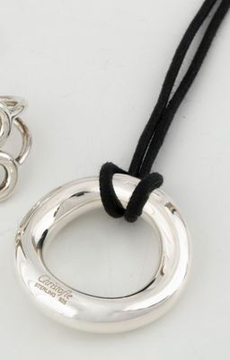 deux bijoux en argent posés sur une surface blanche