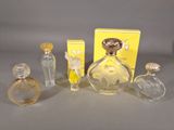 three perfume bottles and a box of perfume sitting on a table