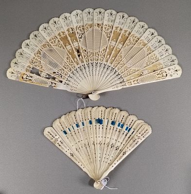 a white fan hanging on the wall next to a mirror