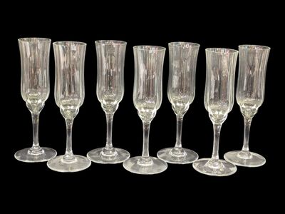 six verres à vin transparents alignés sur un fond noir