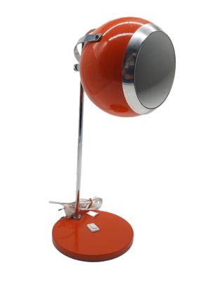 une photo d'une lampe de bureau rouge posée sur un pied métallique