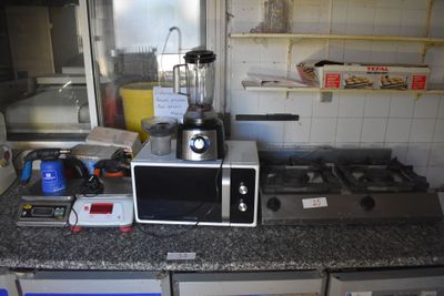 un micro-ondes et un mixeur posés sur le plan de travail d'une cuisine